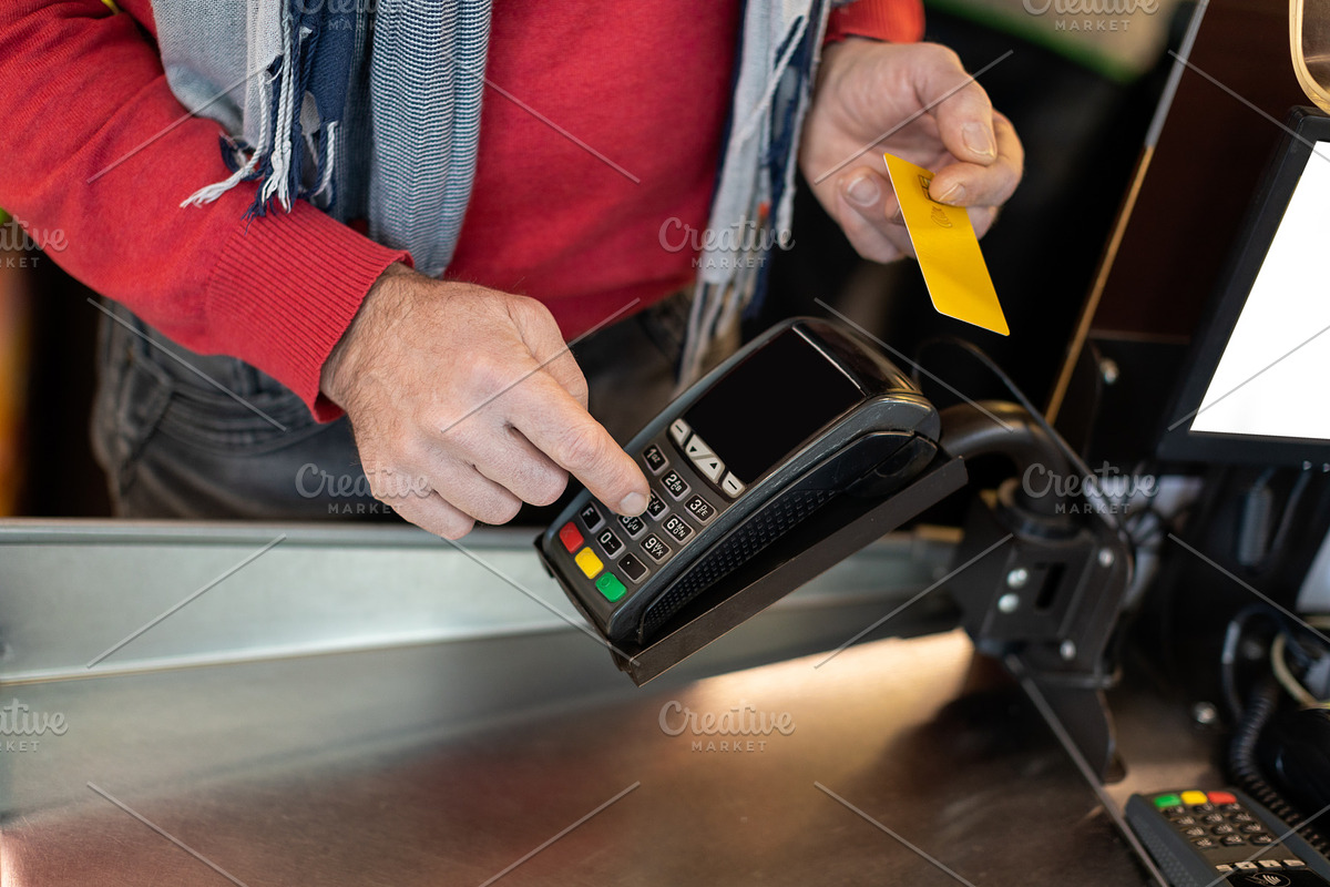 Unrecognizable male customer paying with credit card, a Photo by Prostock-Studio (Photo 1 of 2)
