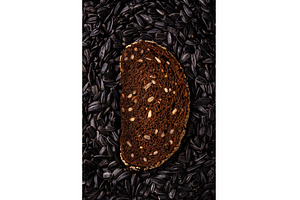 Slice of rye bread on black seed, a Food & Drink Photo by Yulia Furman