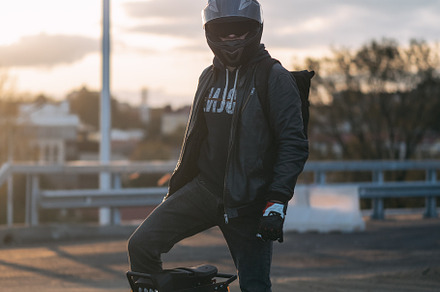 young male rider in protective gear with a backpack on an electric unicycle. Dr
