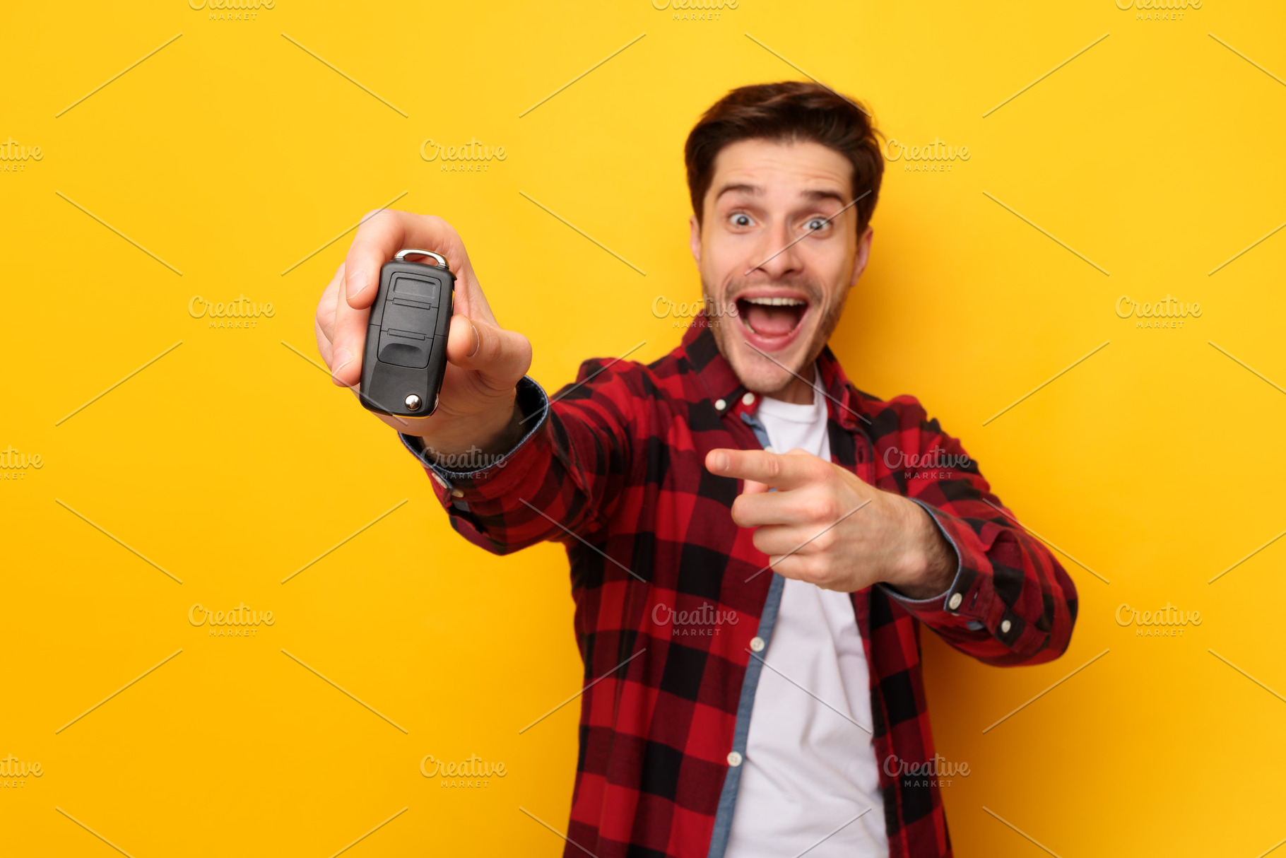 Excited Man Holding Car Key And Pointing, Yellow Background, a Photo by Prostock-Studio
