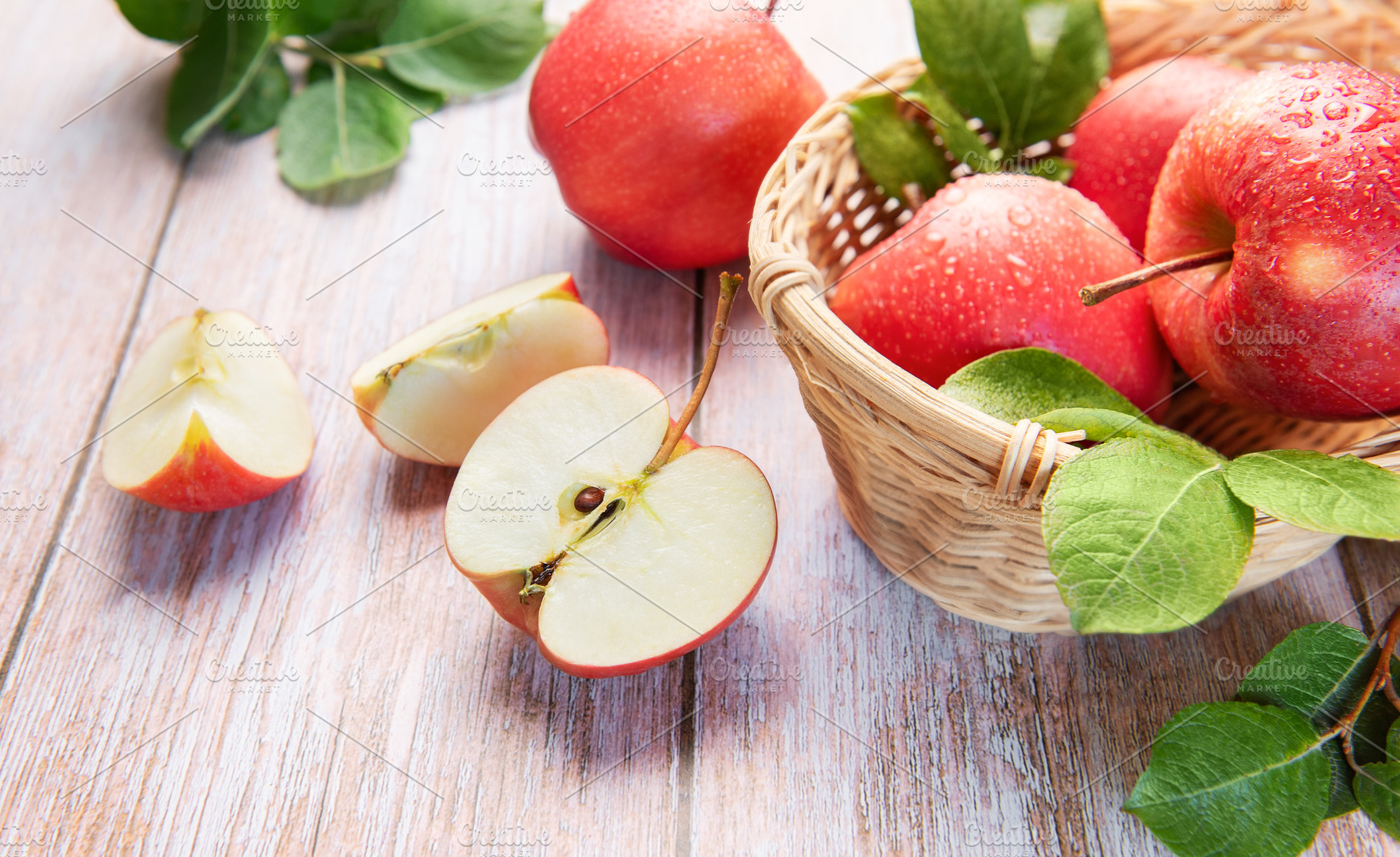 Fresh red apples in basket with green leaves, a Food & Drink Photo by Olena Rudo