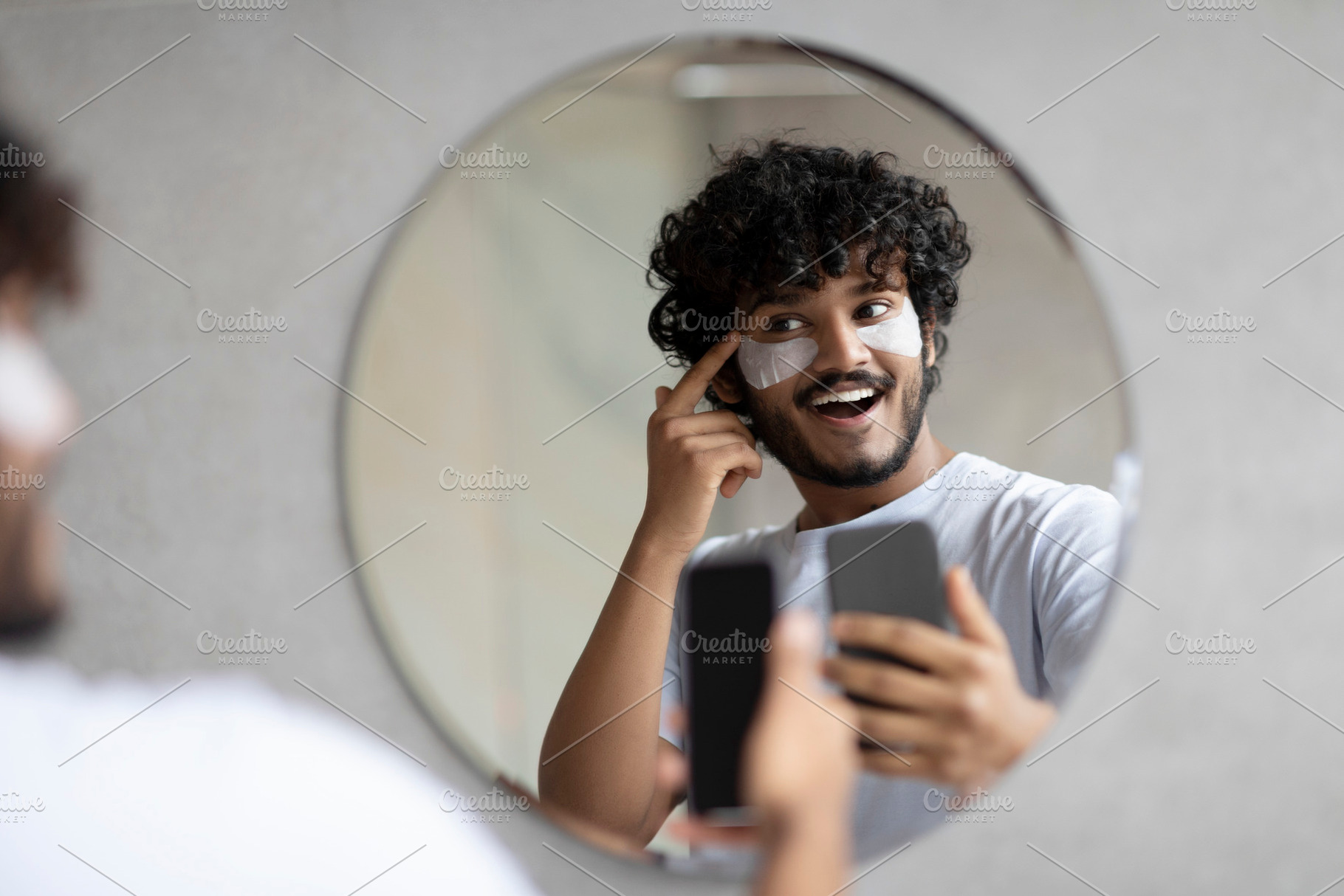 Excited indian man with eye patches taking photo on cellphone, looking and smil, a Person Photo by Prostock-Studio