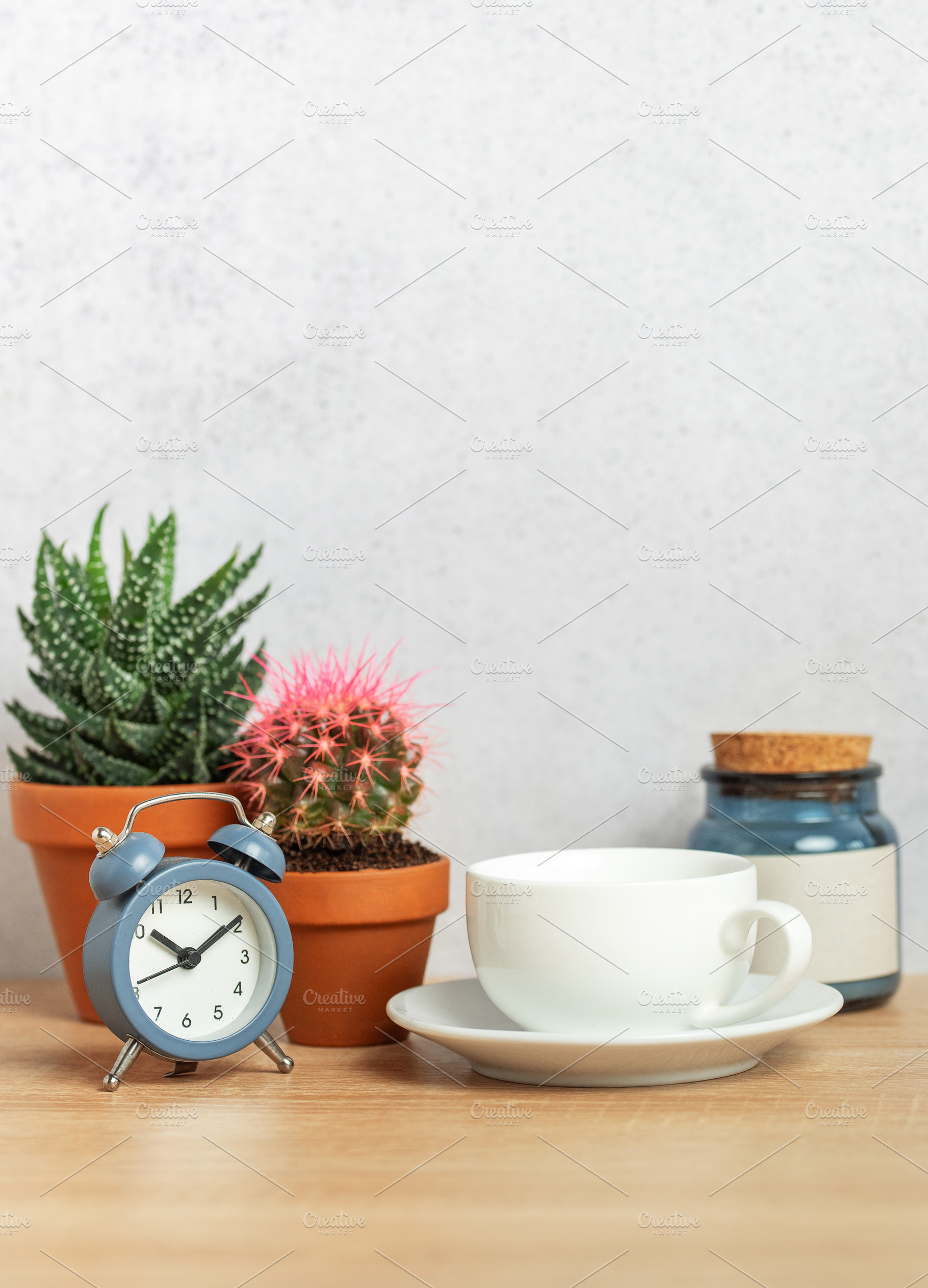 Coffee cup, alarm clock and cacti creating relaxing morning atmo, a Background Photo by Olena Rudo