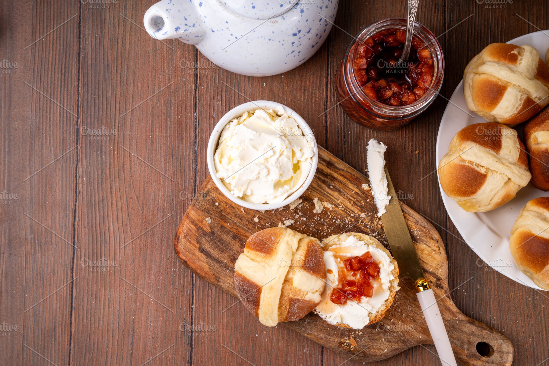 Traditional Easter hot cross bun with clotted cream and jam, a Food & Drink Photo by Rimma