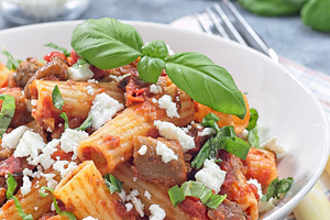 Rigatoni alla Norma pasta with eggplant and tomato, served with basil and ricot, a Food & Drink Photo by iuliia_n