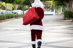 Santa Claus walking through the city with a red gift sack, a Holiday Photo by etorres69