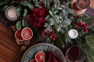 Elegant Christmas dinner table set with plaid runner, candles, pine, foliage, a, a Food & Drink Photo by Studio ANNA