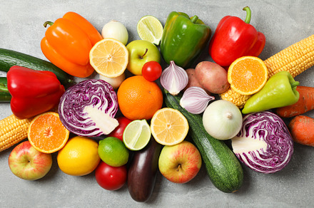 Different vegetables and fruits on grey background, top view, a Food & Drink Photo by AtlasStudio