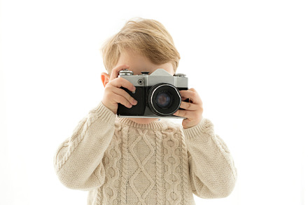 A little boy with a camera in his ha