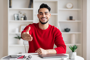 Cheerful friendly attractive young arab businessman with beard in red clothes g, a Photo by Prostock-Studio
