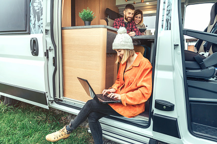 Woman teleworking sitting in the door of a camper van, a Person Photo by davidpereiras