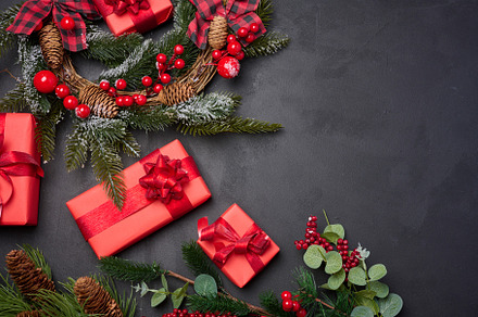 Christmas wreaths, fir branches and gifts on a black background., a Holiday Photo by ndanko