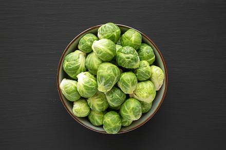 Raw Organic Brussel Sprouts in a Bowl on a black background, top, a Food & Drink Photo by LiudmylaChuhunova