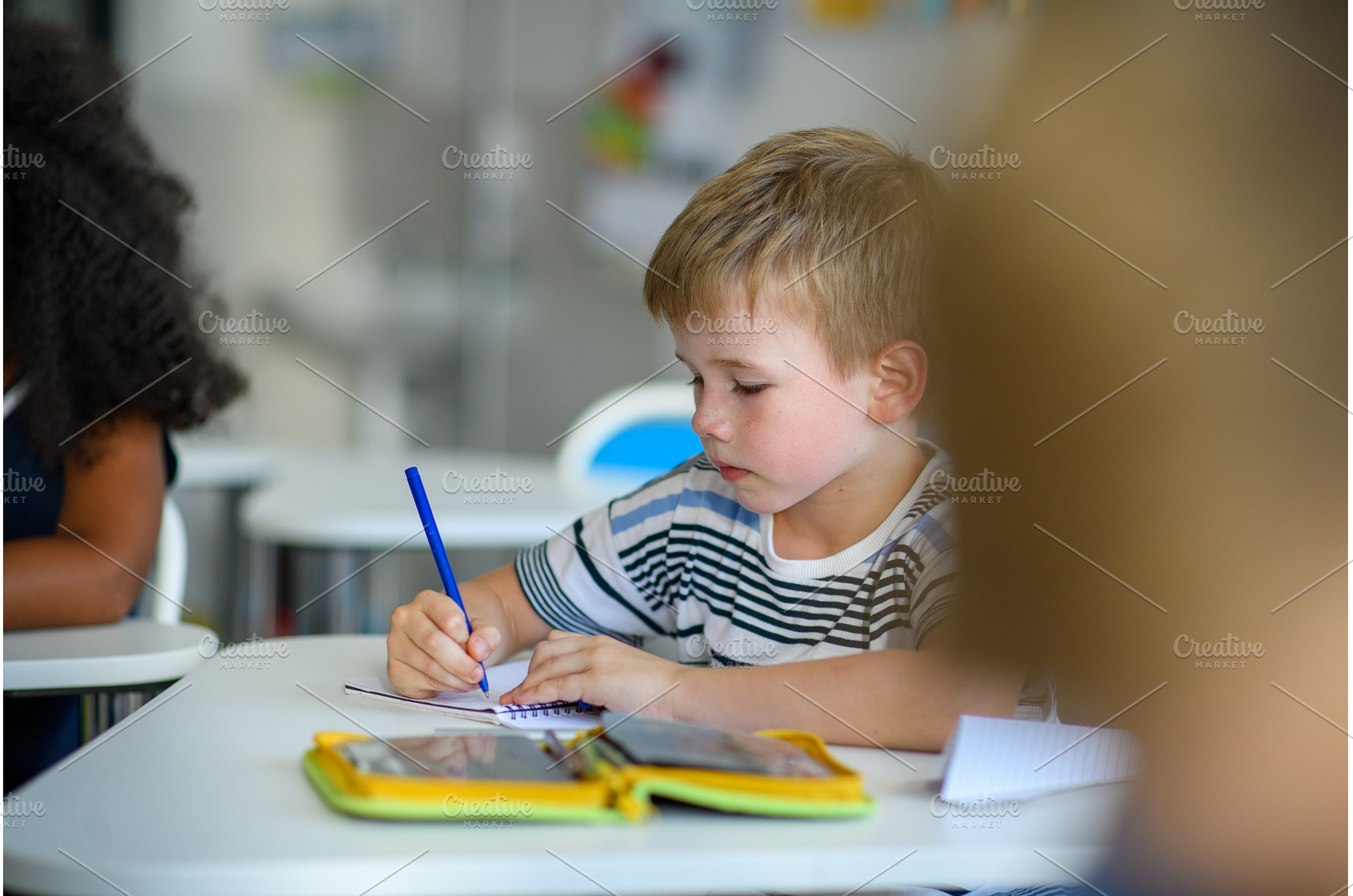 School boy sitting at the desk in, a Person Photo by HalfPoint