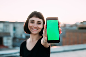Young woman smiles with phone featuring background, woman, and technology, a Technology Photo by DeRepente