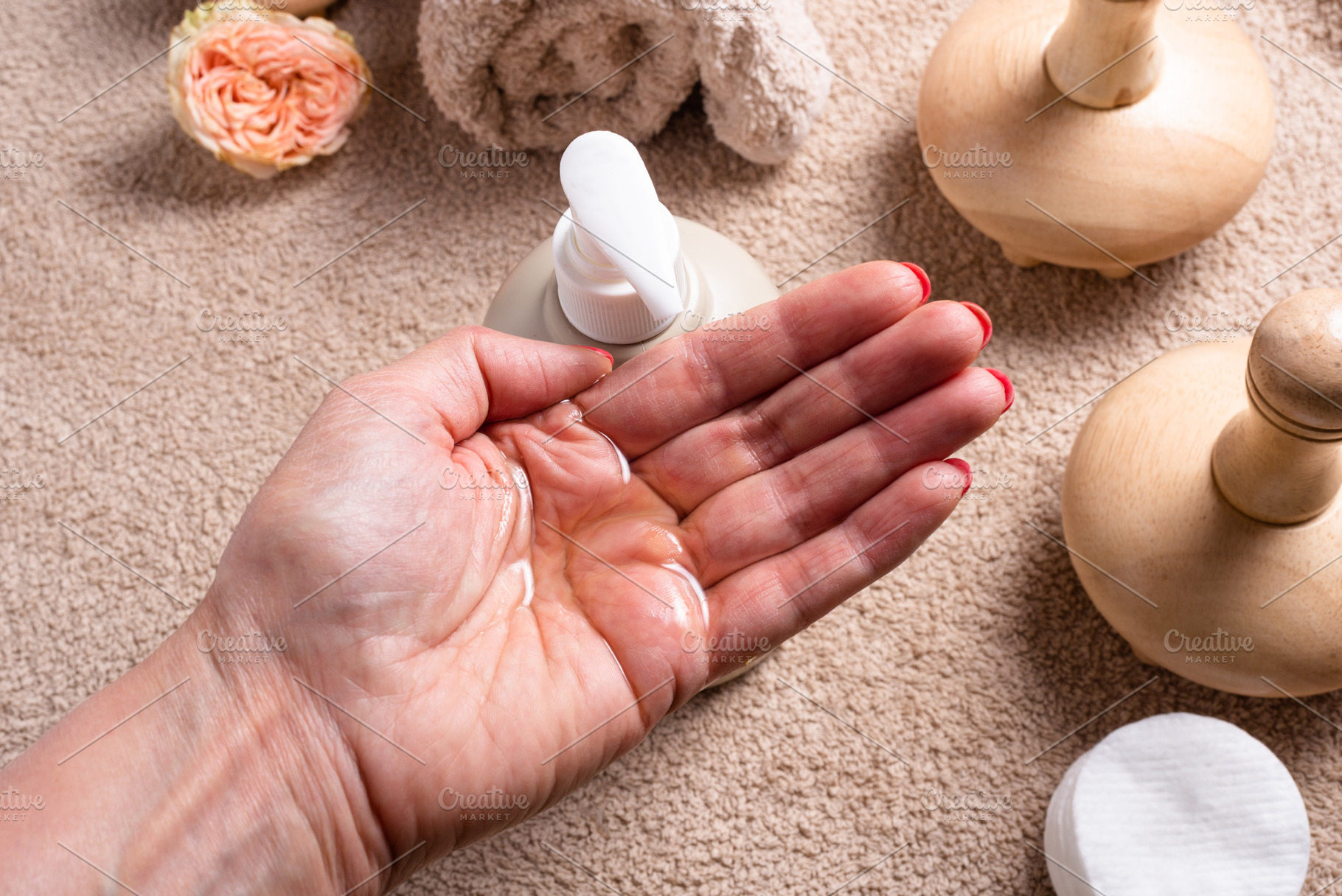 Woman hand holds oil, bottle with dispenser for massage oil on b, a Health & Medical Photo by MDBildes