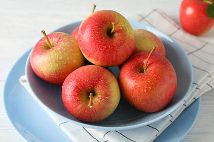 Composition with plate and apples on white wooden background, cl, a Food & Drink Photo by AtlasStudio
