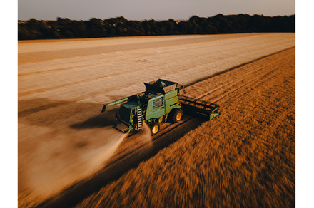 Aerial view of a harvester working, an Industrial Photo by HalfPoint