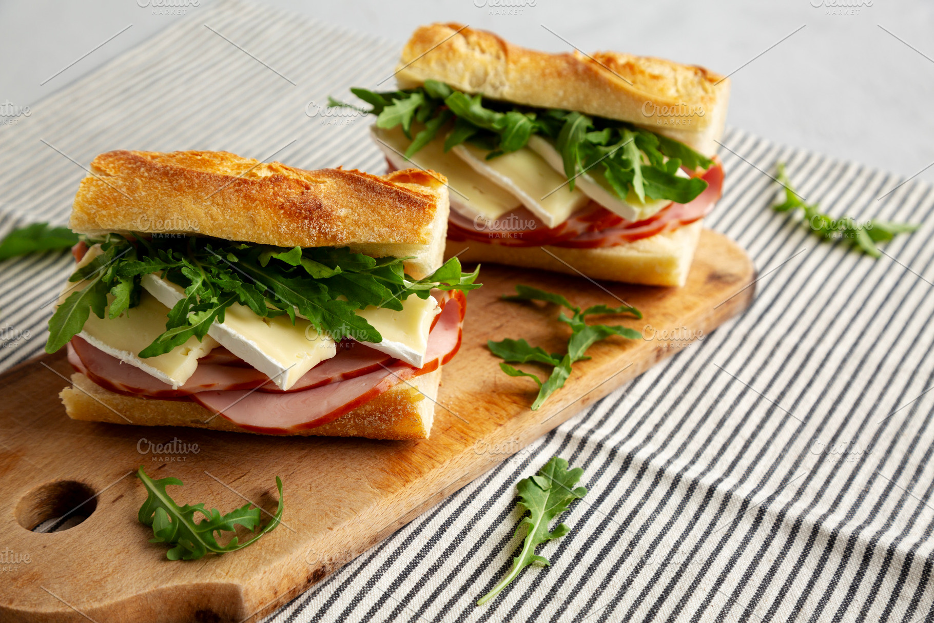 Homemade French Ham and Brie Baguette with Arugula Greens, side, a Food & Drink Photo by LiudmylaChuhunova