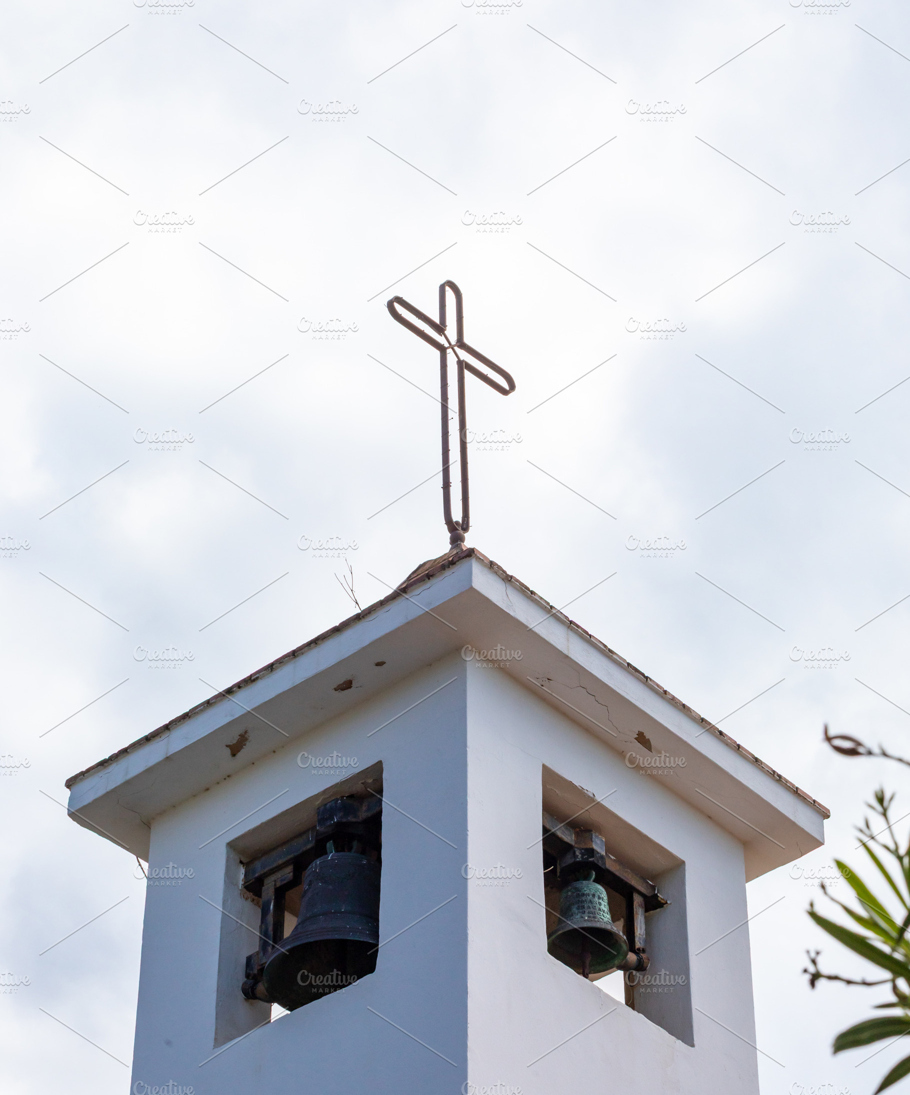 Simple white bell tower with metal cross and two bells standing out against clo, a Photo by Antonio Gravante Market