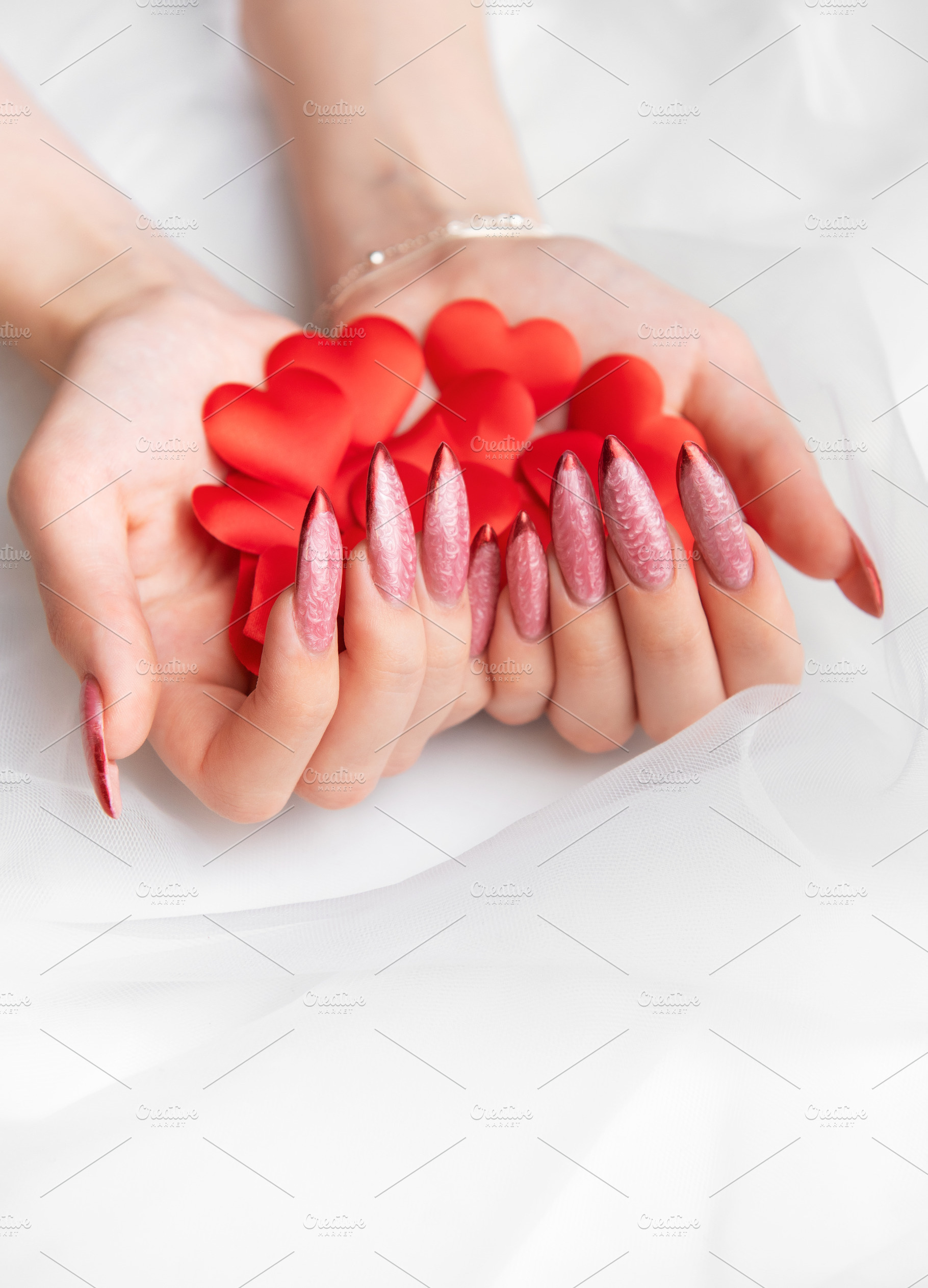 Woman holding red hearts with elegant manicure nails, a Beauty & Fashion Photo by Olena Rudo