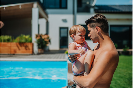 Father and young daughter standing