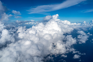 Aerial view of fluffy clouds over the Pacific Ocean in Polynesia, a Photo by GoodGoods