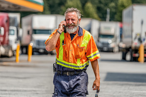 Happy trucker talking on phone at tr, a Photo by Pixeness Studio