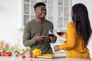 Aperitif Drink. Cheerful Black Man And Woman Drinking Red Wine In Kitchen, a Photo by Prostock-Studio