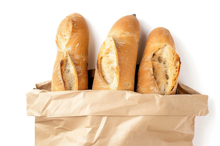 Freshly baked baguette in paper bag isolated on white background, a Food & Drink Photo by AlyaAnd
