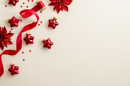 Beige Christmas background with red Christmas decorations, ribbon, confetti. Fl, a Holiday Photo by photoguns