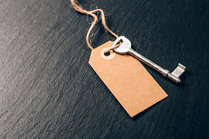 Key on blank kraft tag on slate