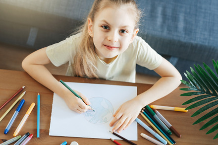 Child girl drawing with colorful pencils, a Person Photo by Olena Rudo