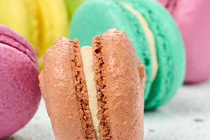 An assortment of colorful macarons on a white surface with dark, a Food & Drink Photo by ndanko