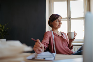 Female designer having coffee break, a Beauty & Fashion Photo by HalfPoint