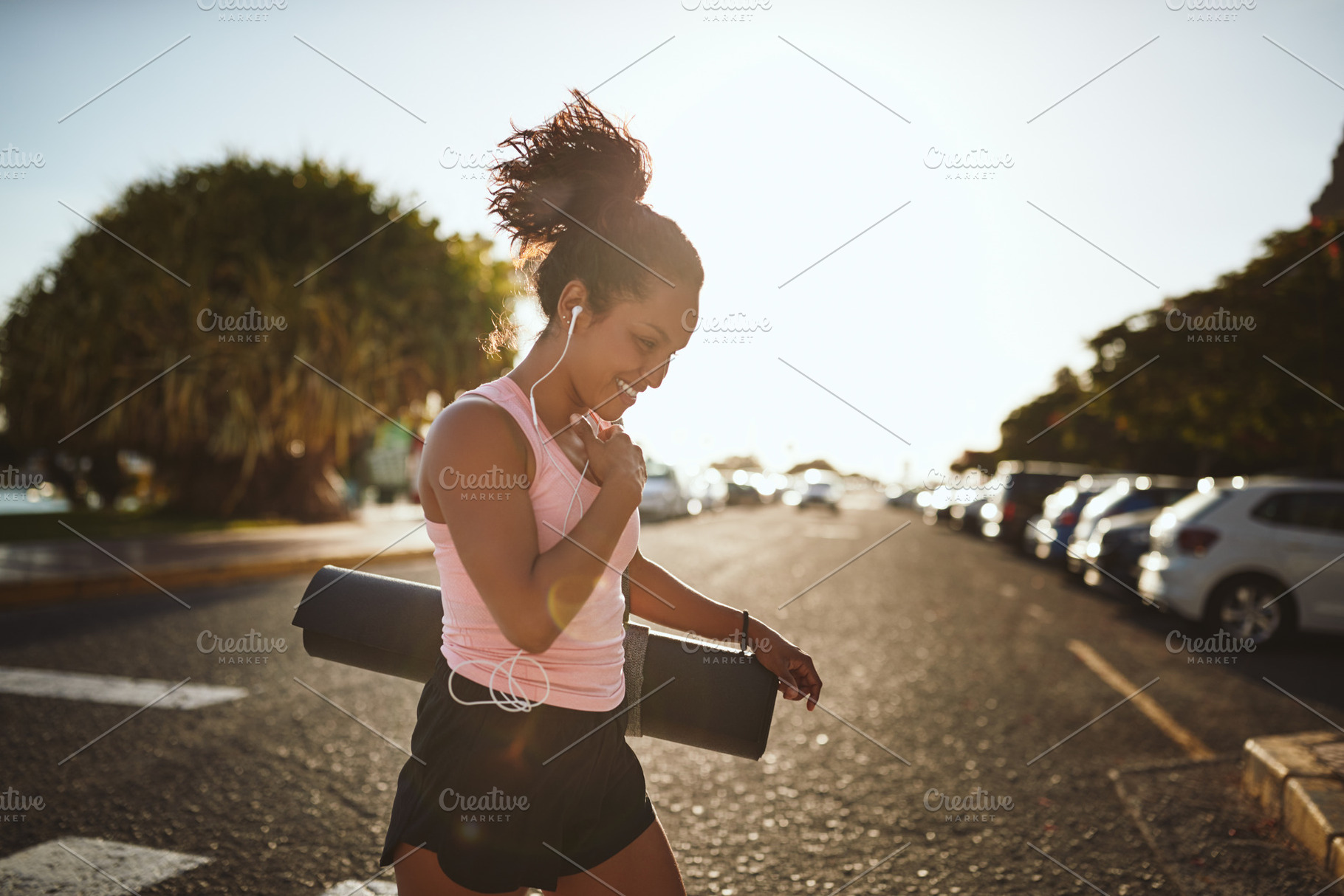Smiling woman walking to her yoga class listening to music, a Sports & Recreation Photo by Stefan & Janni