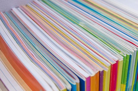 Many books pile on wooden table at library, a School & Education Photo by Casanowe-studio