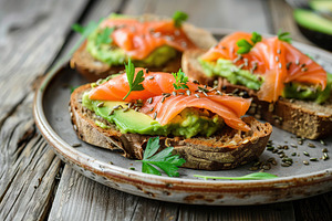 Toast bread with salted salmon and guacamole avocado on wooden table, a Food & Drink Photo by AlyaAnd