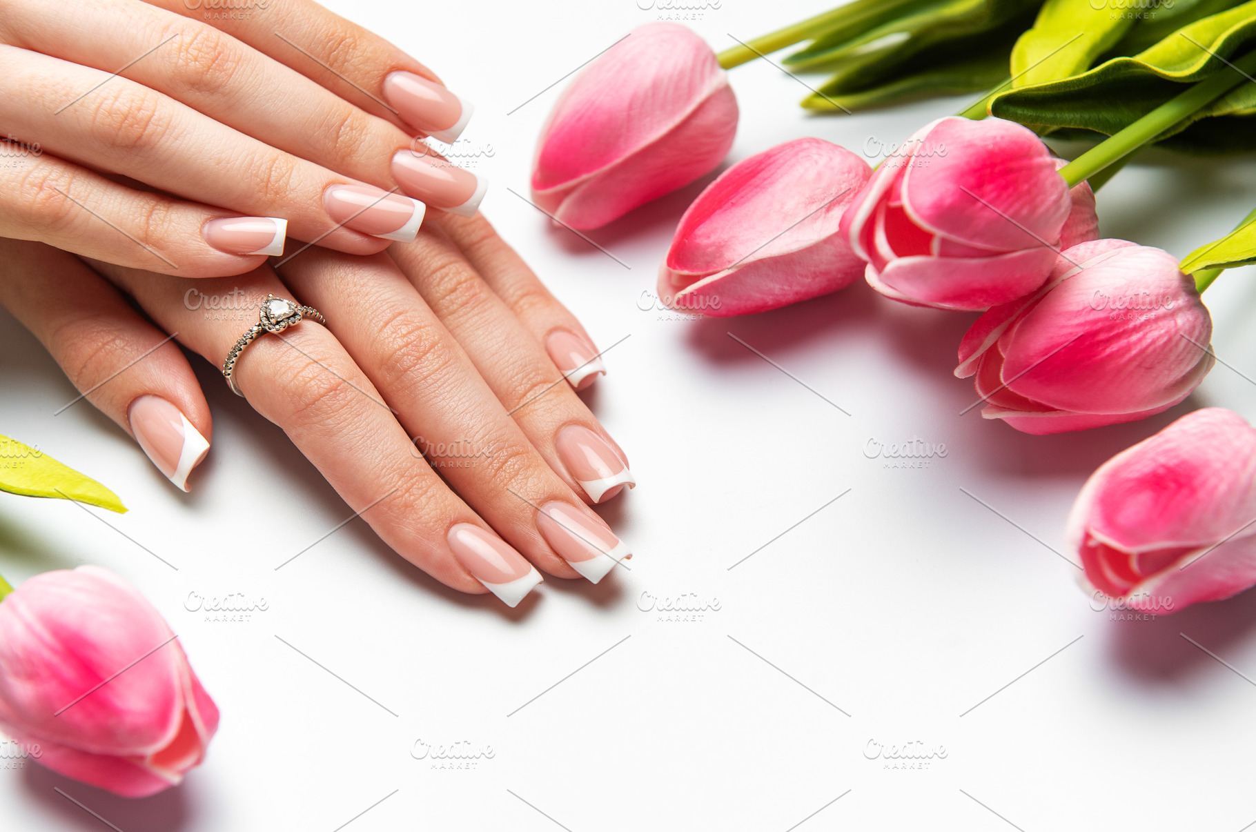 Woman showing french manicure and pink tulips on white backgroun, a Beauty & Fashion Photo by Olena Rudo