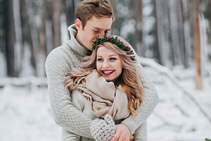 Happy newlyweds are hugging in the winter forest couple in love winter