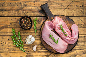 Fresh uncooked pork tongue arranged on round wooden board with h, a Food & Drink Photo by composter-box@mail.ru