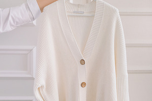 Arm holding out the white sweater, a Photo by Nina Stock Photos