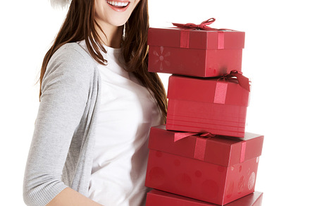 Beautiful woman in santa hat holding presents.