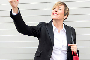 Businesswoman taking selfie with smartphone outdoors, a Photo by RF Images