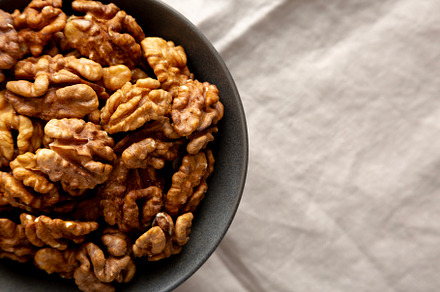 Raw Walnut Halfs in a Bowl, top view. Flat lay, overhead. Copy s