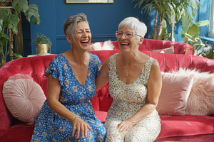 Two women laugh in a cozy room, a Photo by Beautiful things