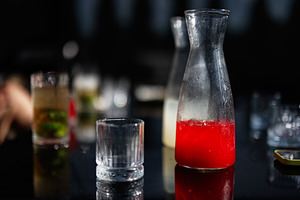 Elegant table setting featuring beverages in glass jars and stylish glasses, a Photo by AS photostudio