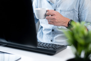 Man Drinking Coffee While Working at Computer in Home Office, a Person Photo by etorres69