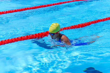 Swimmer child swims breaststroke swimming style in a race swimmi