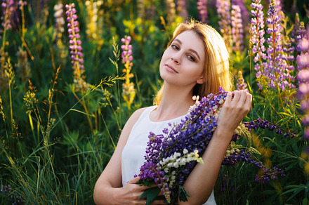 A beautiful blonde in a white dress with a bouquet of wildflowers. Bouquet of l